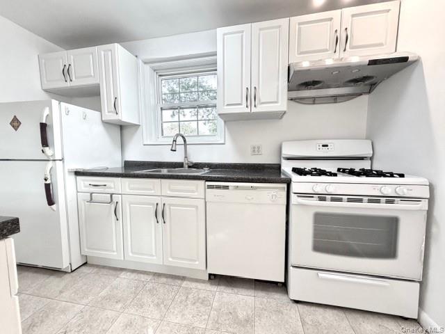 65-26B 223rd Place, Unit 2 Queens, NY 11364 - Photo 9 of 30 Kitchen with white appliances, dark countertops, under EXTRA WINDOW -east facing in kitchen -cabinet range hood, and white cabinets
