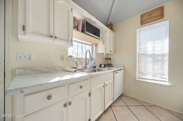 a kitchen with white cabinets and white appliances