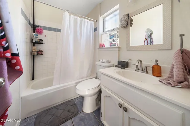 a bedroom with a bed and a flat tv screen on the dresser