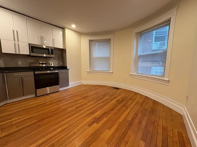 a kitchen with stainless steel appliances granite countertop a stove and a wooden floors