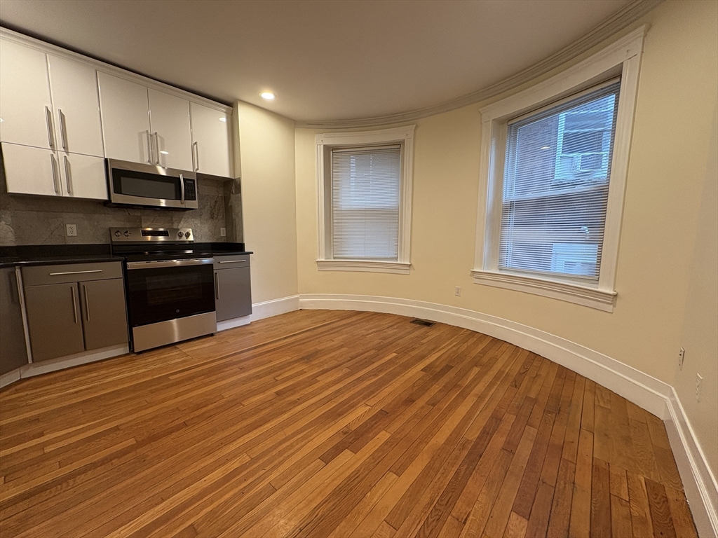 191 Winthrop Road, Unit 1 Brookline, MA 02445 - Photo 1 of 15 a kitchen with stainless steel appliances granite countertop a stove and a wooden floors