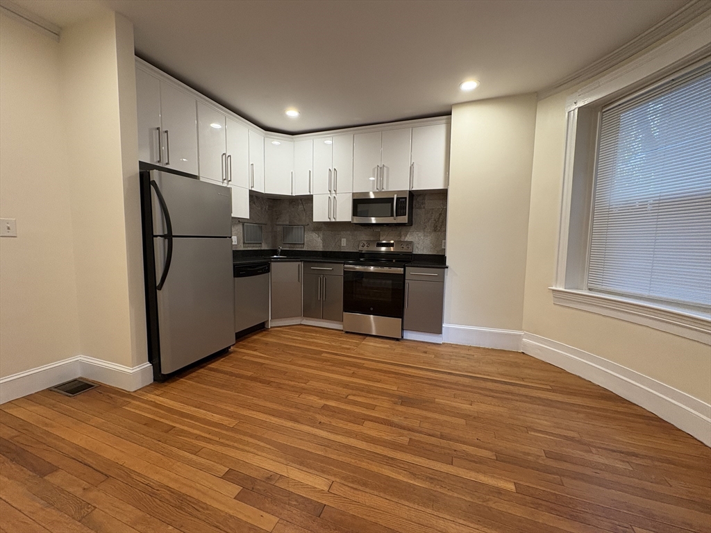 191 Winthrop Road, Unit 1 Brookline, MA 02445 - Photo 2 of 15 a kitchen with stainless steel appliances granite countertop a refrigerator and a stove top oven