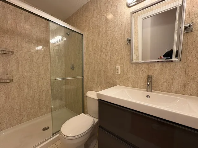 a bathroom with a sink a toilet and shower