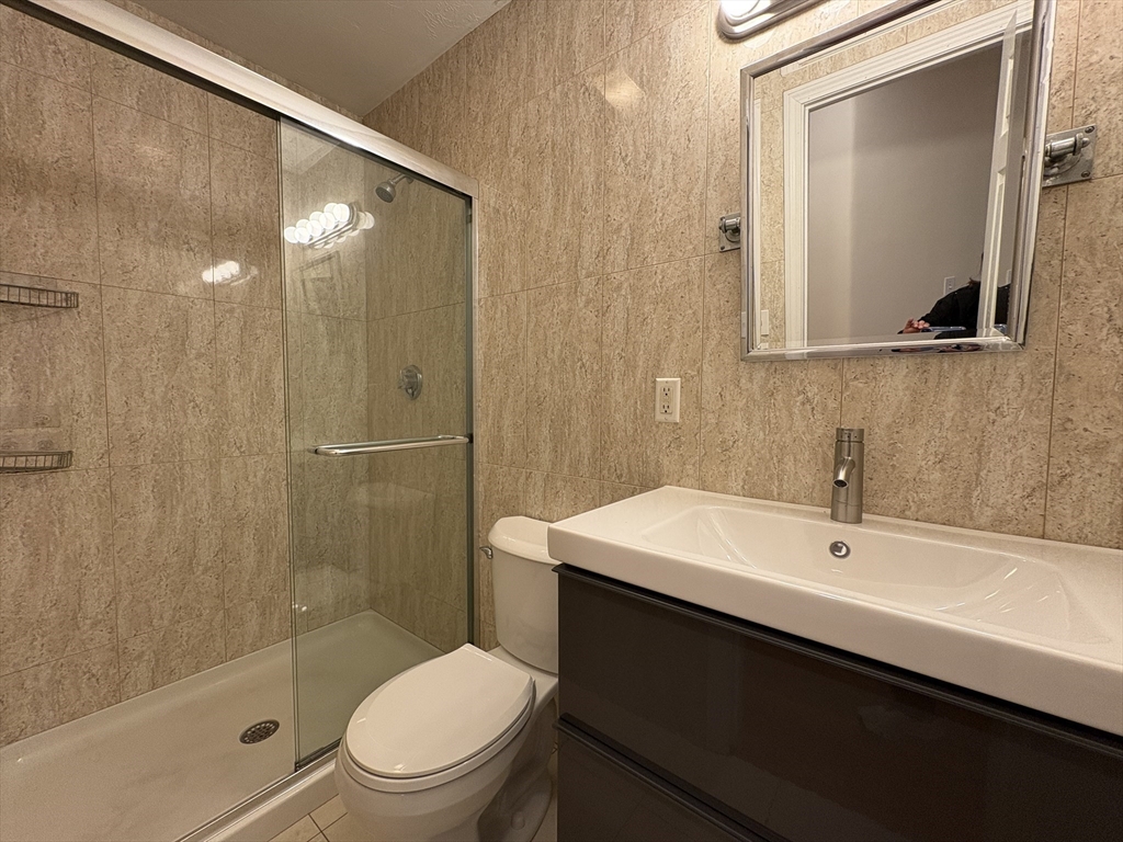 191 Winthrop Road, Unit 1 Brookline, MA 02445 - Photo 4 of 15 a bathroom with a sink a toilet and shower