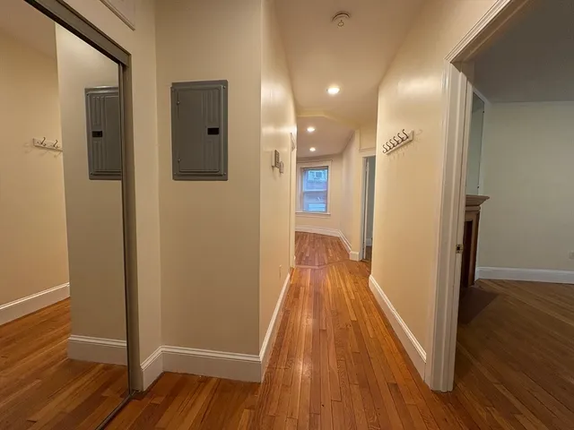 a view of a hallway with wooden floor and staircase