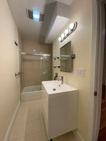a bathroom with a sink a shower and a mirror