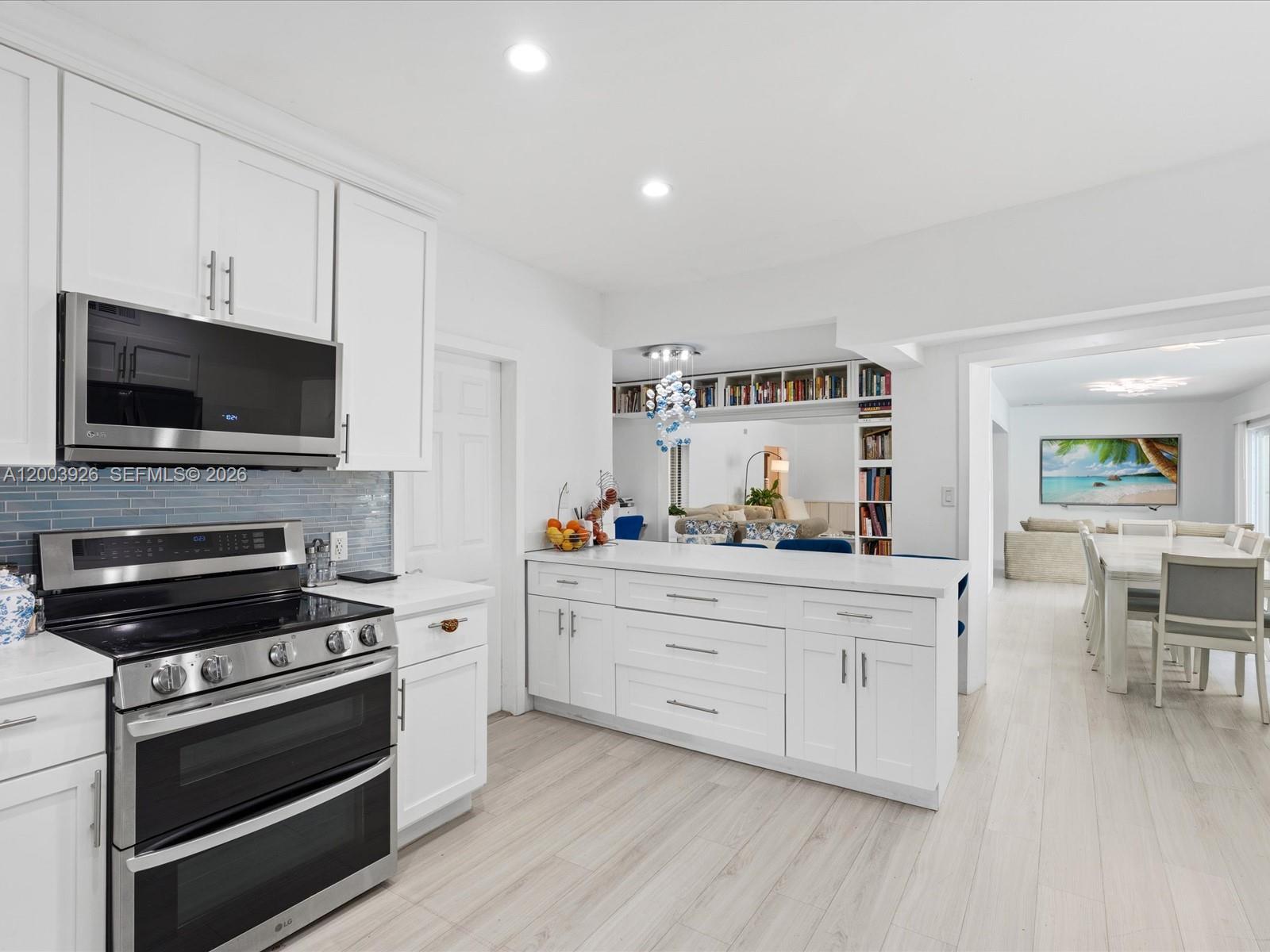 5000 Riviera Drive Coral Gables, FL 33146 - Photo 20 of 80 a kitchen with stainless steel appliances a stove cabinets and a wooden floor