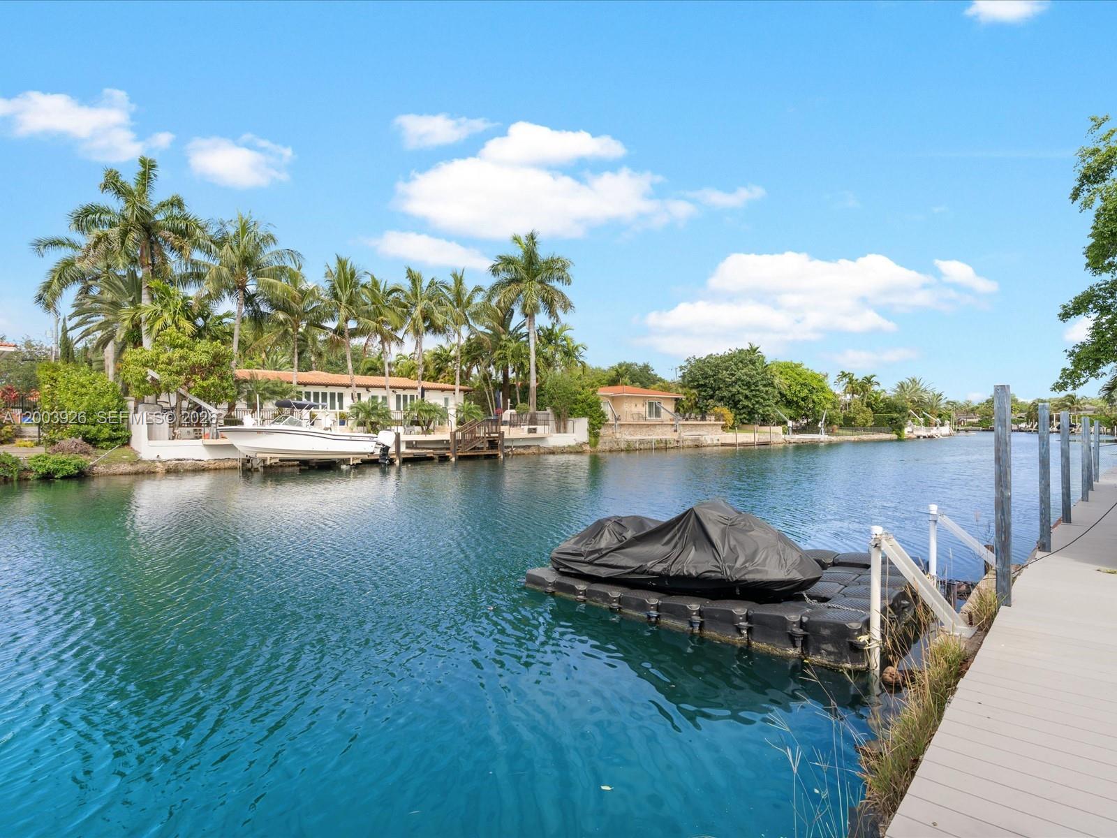 5000 Riviera Drive Coral Gables, FL 33146 - Photo 2 of 80 a lake view with boat and palm trees