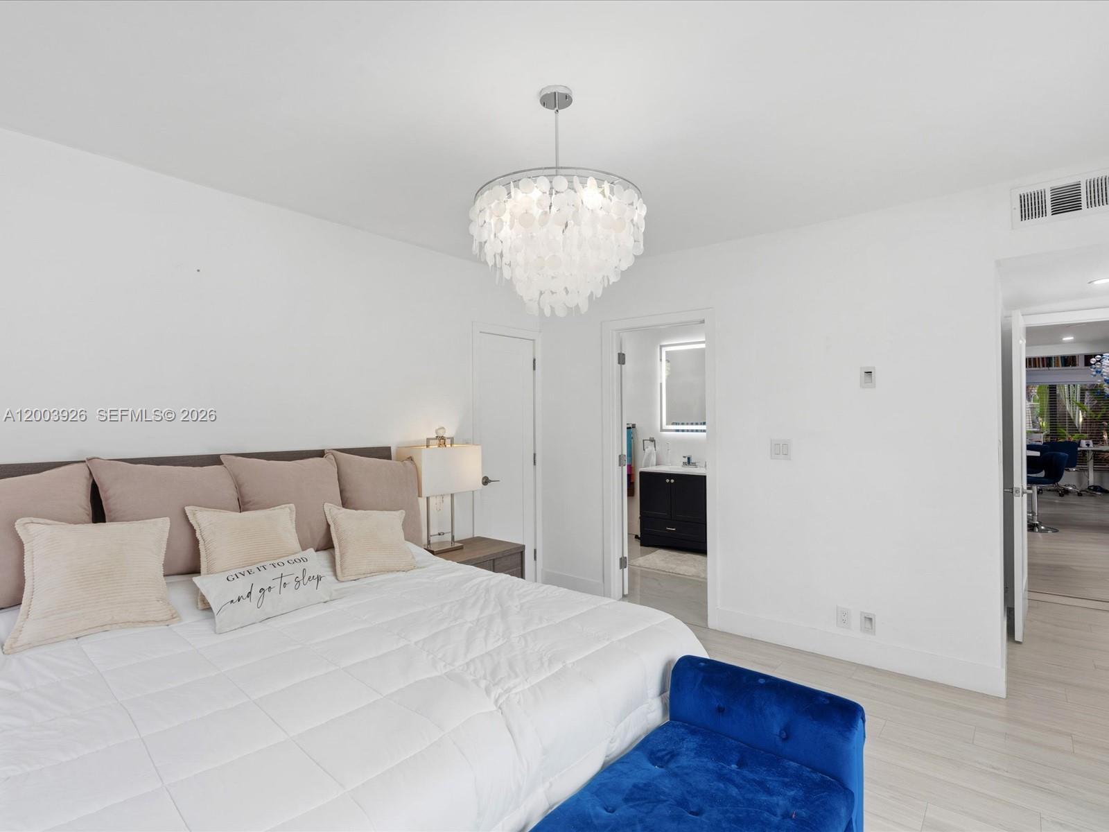 5000 Riviera Drive Coral Gables, FL 33146 - Photo 33 of 80 a bedroom with a large bed and a chandelier