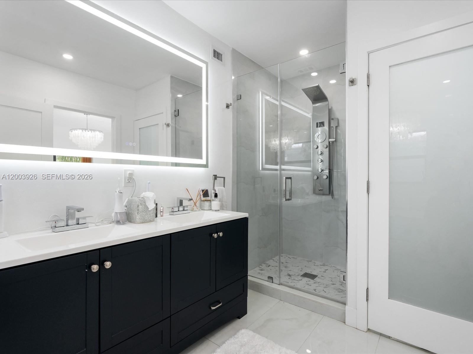 5000 Riviera Drive Coral Gables, FL 33146 - Photo 37 of 80 a bathroom with a shower sink double vanity and mirror