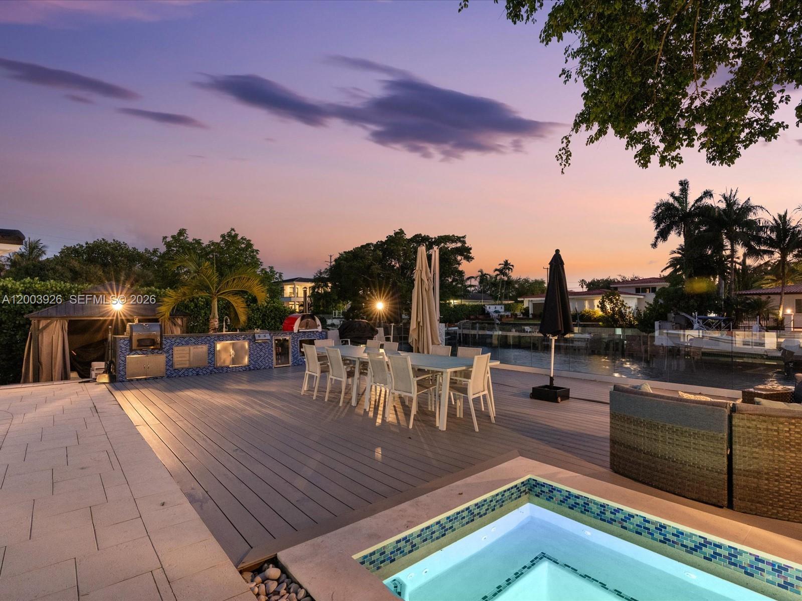 5000 Riviera Drive Coral Gables, FL 33146 - Photo 5 of 80 a view of a patio with dining table and chairs with a fire pit