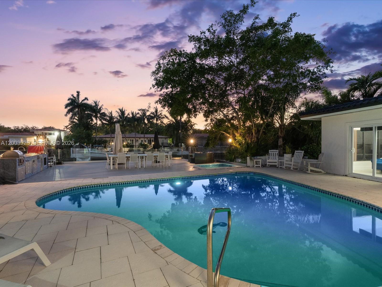 5000 Riviera Drive Coral Gables, FL 33146 - Photo 67 of 80 a view of swimming pool with seating space and trees in the background