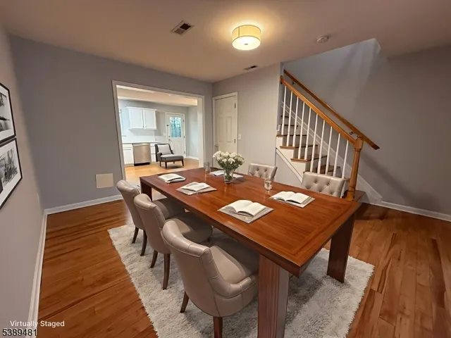 a view of a dining room and livingroom with furniture wooden floor a rug and a chandelier