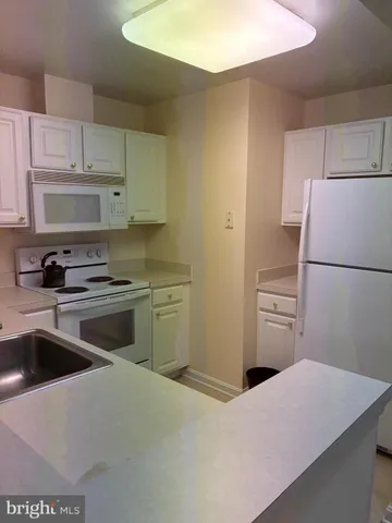 a kitchen with a stove sink and cabinets