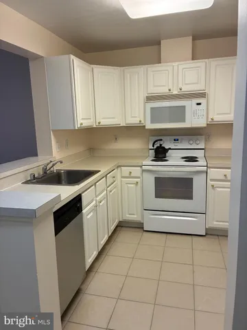 a bedroom with a bed and a refrigerator