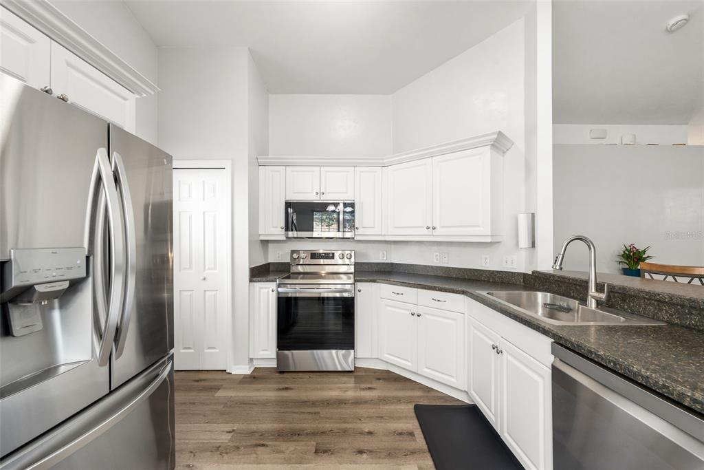 4928 Southwest 63rd Lane Gainesville, FL 32608 - Photo 12 of 32 a kitchen with stainless steel appliances granite countertop a refrigerator sink and stove