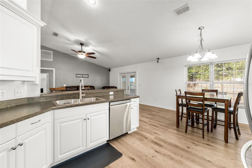 4928 Southwest 63rd Lane Gainesville, FL 32608 - Photo 13 of 32 a kitchen with granite countertop white cabinets and counter space