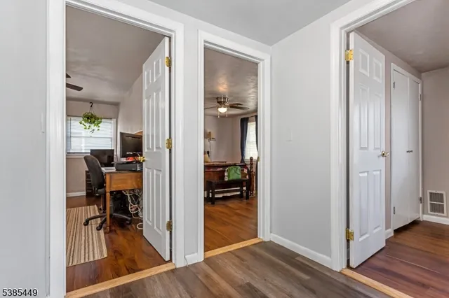a view of a hallway with dining room and wooden floor