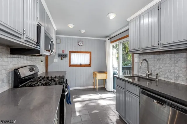 a kitchen with stainless steel appliances granite countertop a sink stove and cabinets