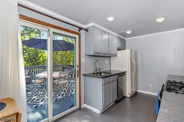 a kitchen with stainless steel appliances granite countertop a stove a refrigerator a sink and white cabinets