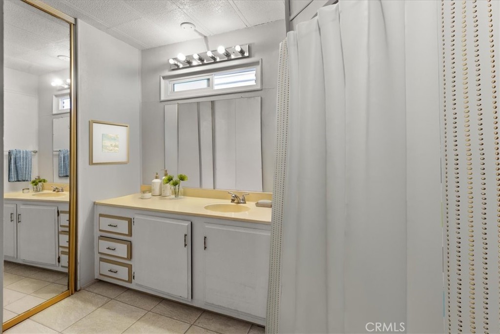 14851 Jeffrey Road, Unit 248 Irvine, CA 92618 - Photo 25 of 27 a bathroom with a double vanity sink and a mirror