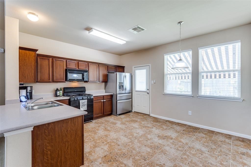 23614 Maple View Drive Spring, TX 77373 - Photo 9 of 23 a kitchen with stainless steel appliances kitchen island granite countertop a stove top oven a sink dishwasher a dining table and chairs with wooden floor