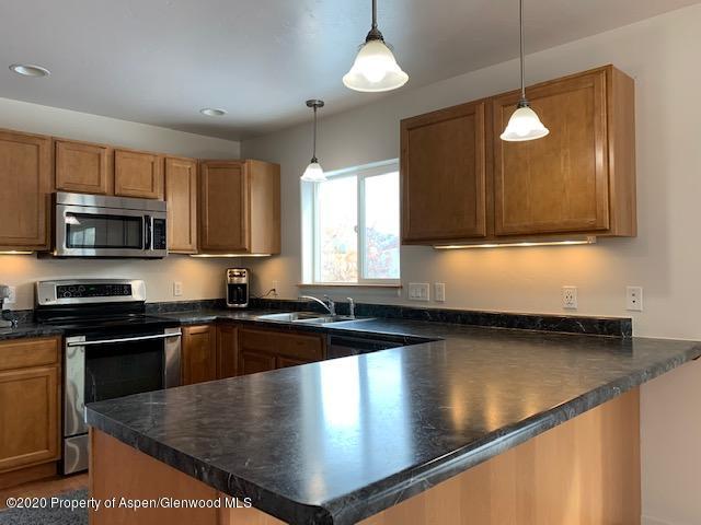 777 East 18th Street Rifle, CO 81650 - Photo 4 of 25 a kitchen with stainless steel appliances granite countertop a sink a stove top oven a counter space and cabinets