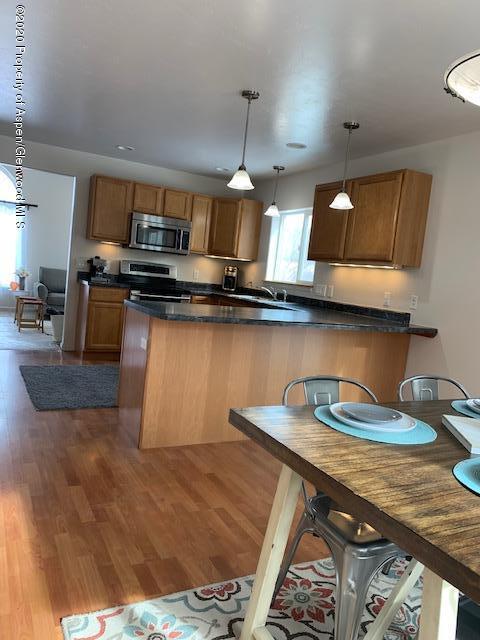 777 East 18th Street Rifle, CO 81650 - Photo 5 of 25 a kitchen with stainless steel appliances granite countertop a sink a stove and a wooden floors