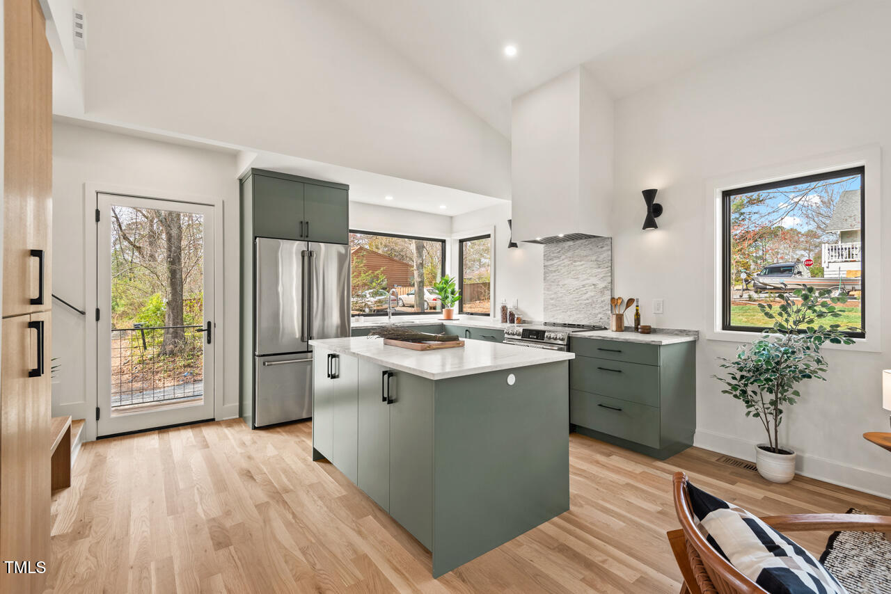 1407 Carroll Street Durham, NC 27707 - Photo 8 of 48 a kitchen with stainless steel appliances granite countertop a lot of counter space and wooden floors