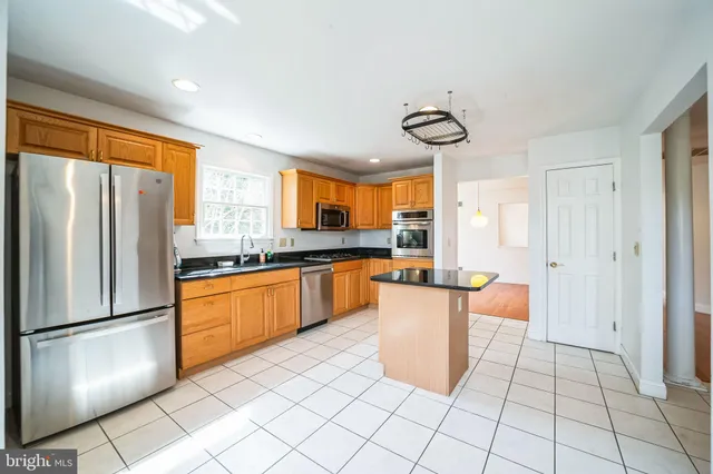 a kitchen with stainless steel appliances granite countertop a refrigerator and a sink