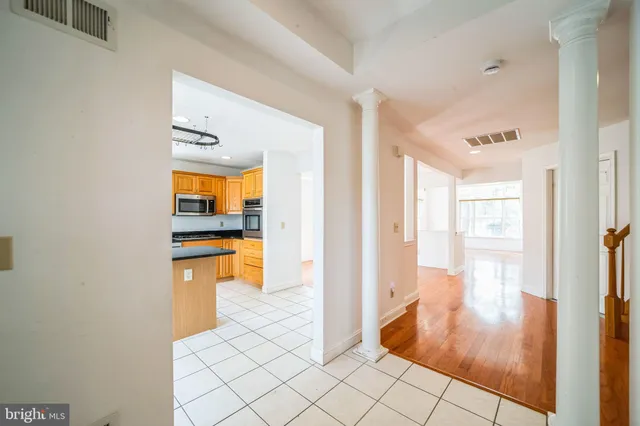a view of a hallway with wooden floor and a bathroom