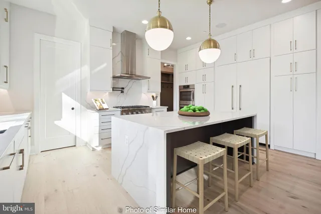 a kitchen with stainless steel appliances kitchen island granite countertop a stove a sink a refrigerator and a dining table with wooden floor