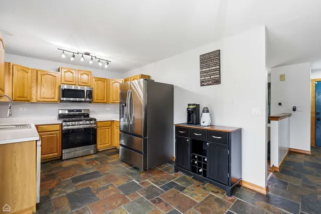 a kitchen with stainless steel appliances granite countertop a refrigerator stove and sink