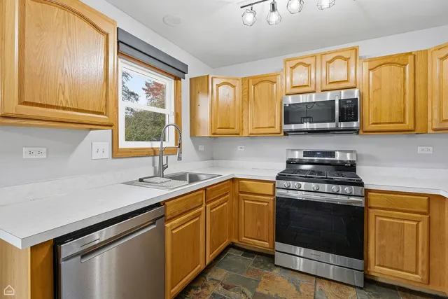 a kitchen with stainless steel appliances granite countertop a stove sink and microwave