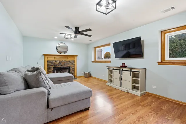 a living room with furniture a flat screen tv and a fireplace