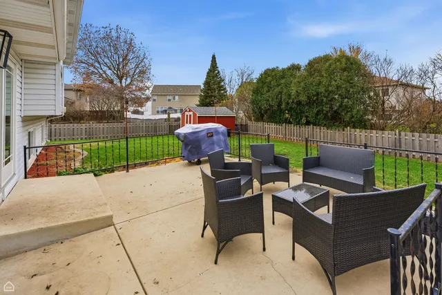 a view of a patio with couches chairs potted plants and a palm tree