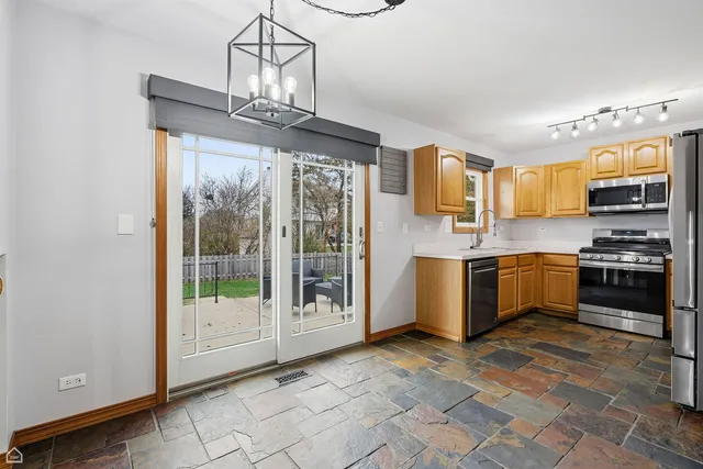 a kitchen with stainless steel appliances granite countertop a stove a sink and a refrigerator