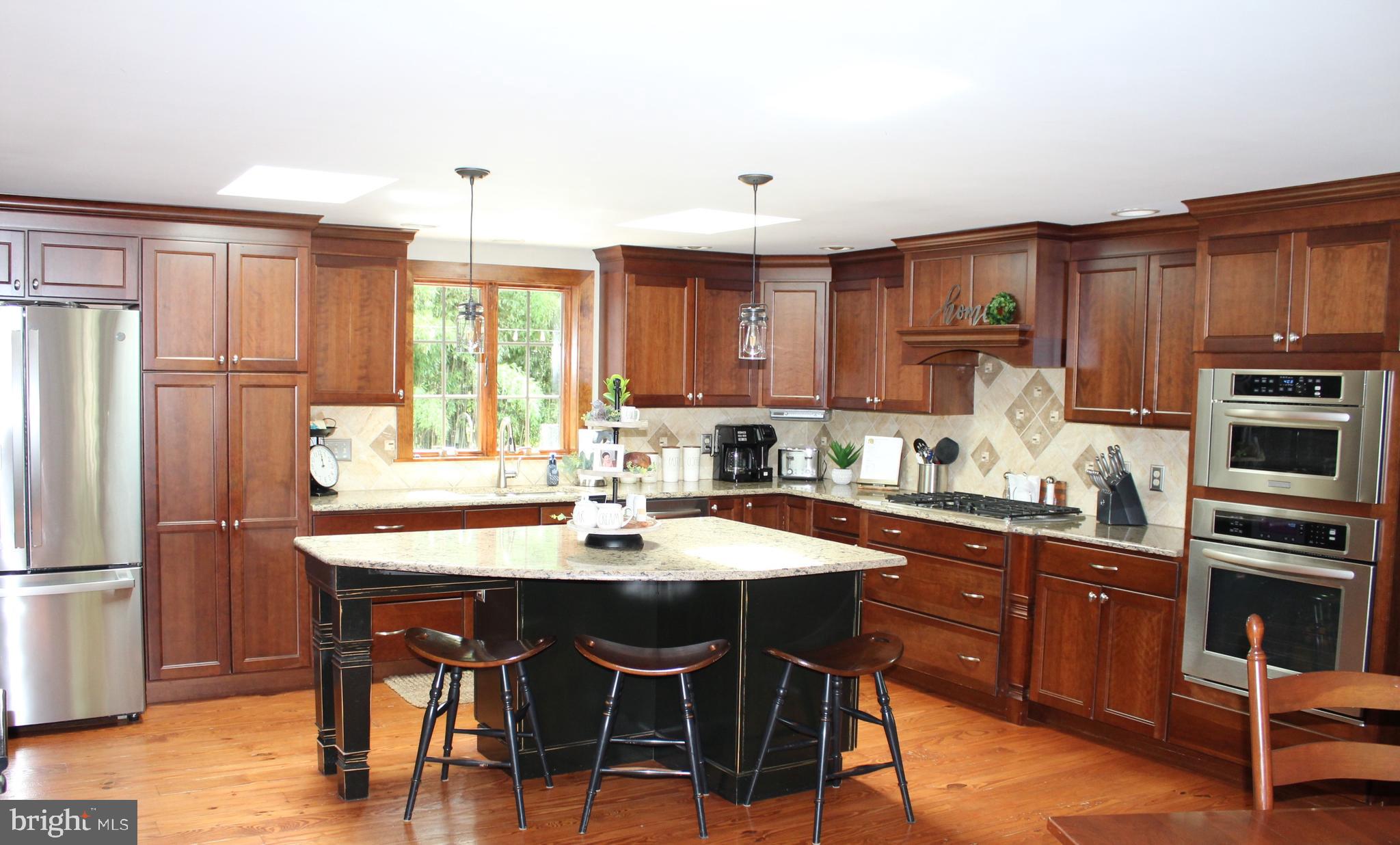 246 Acorn Lane Lititz, PA 17543 - Photo 83 of 120 a kitchen with stainless steel appliances granite countertop a table chairs refrigerator and sink
