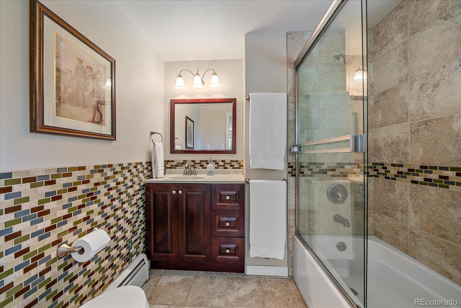 930 Reed Court Lakewood, CO 80214 - Photo 30 of 41 a bathroom with a sink a mirror and a shower