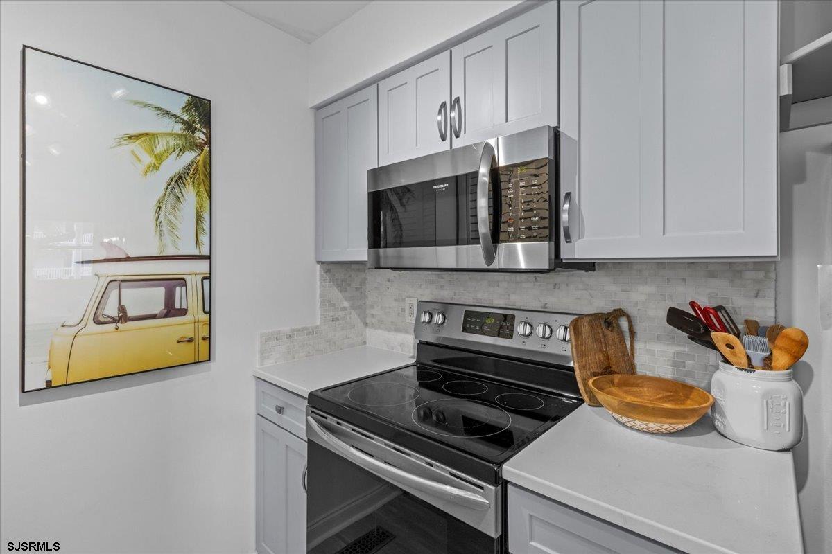 331 41st Street South, Unit 1 Brigantine, NJ 08203 - Photo 11 of 42 a kitchen with stainless steel appliances a stove a microwave and cabinets