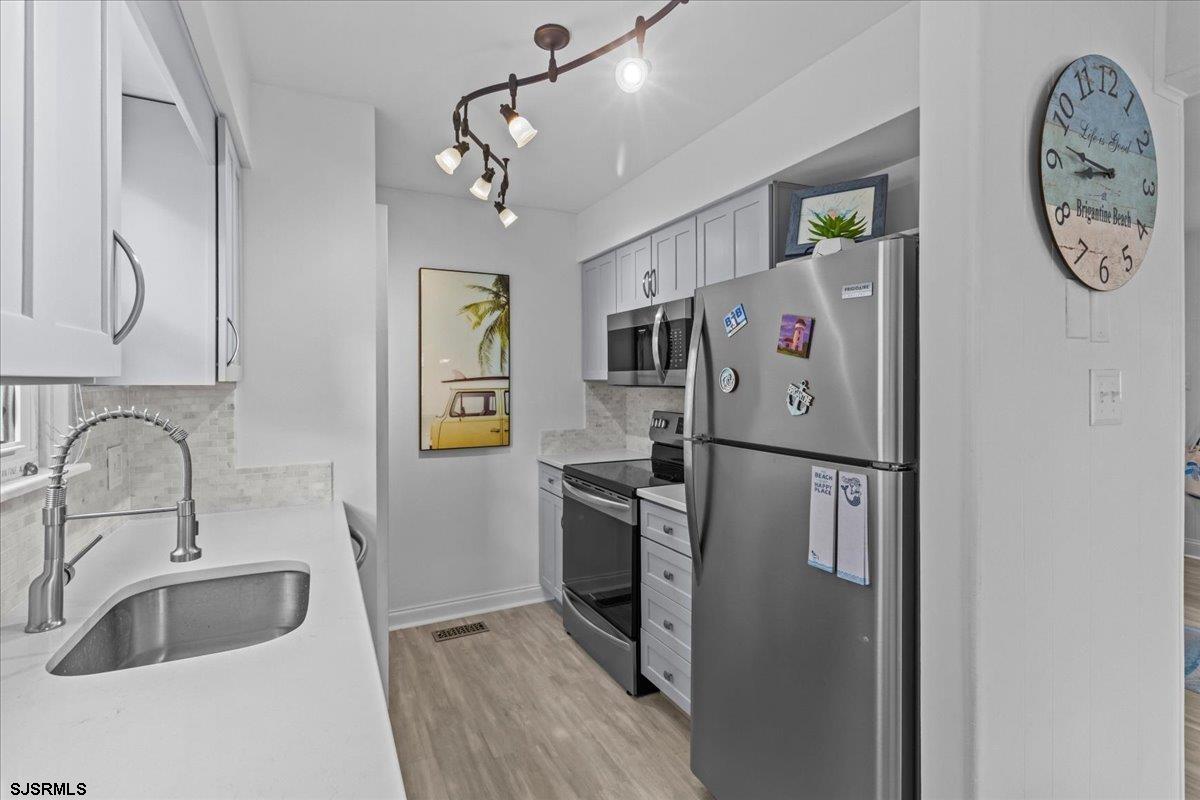 331 41st Street South, Unit 1 Brigantine, NJ 08203 - Photo 13 of 42 a kitchen with stainless steel appliances granite countertop a refrigerator and a sink