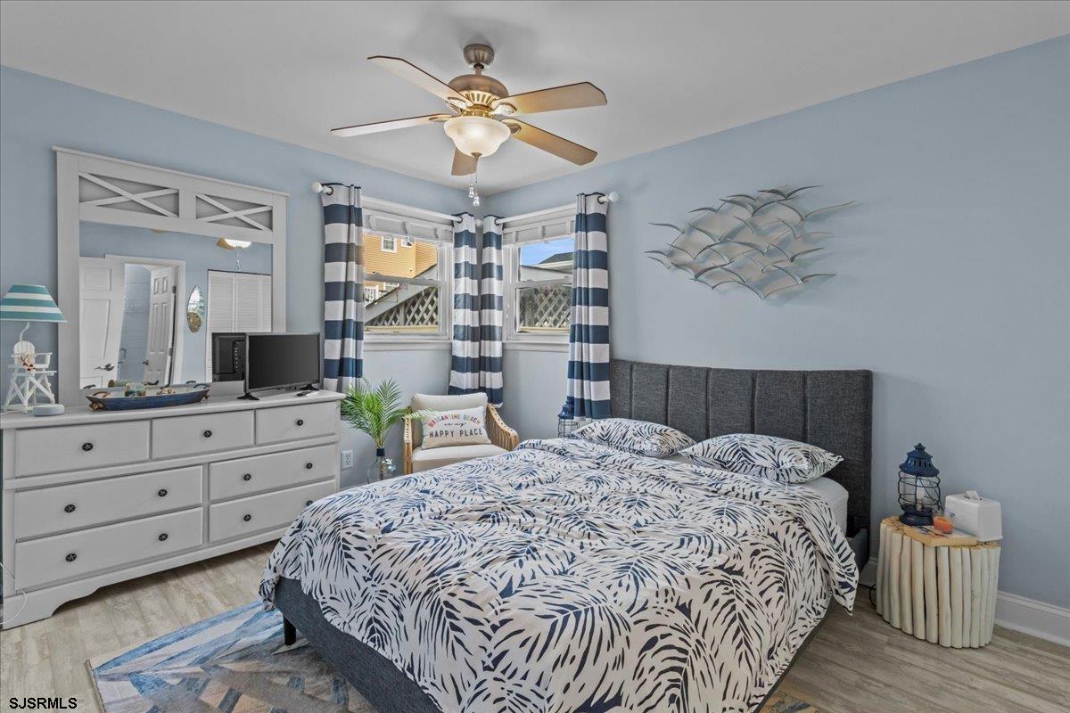331 41st Street South, Unit 1 Brigantine, NJ 08203 - Photo 20 of 42 a bedroom with a large bed and a chandelier