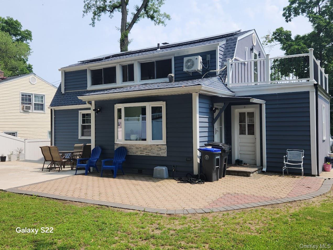 46 Randolph Road White Plains, NY 10607 - Photo 2 of 16 Rear view of property featuring a balcony, a patio, and a lawn