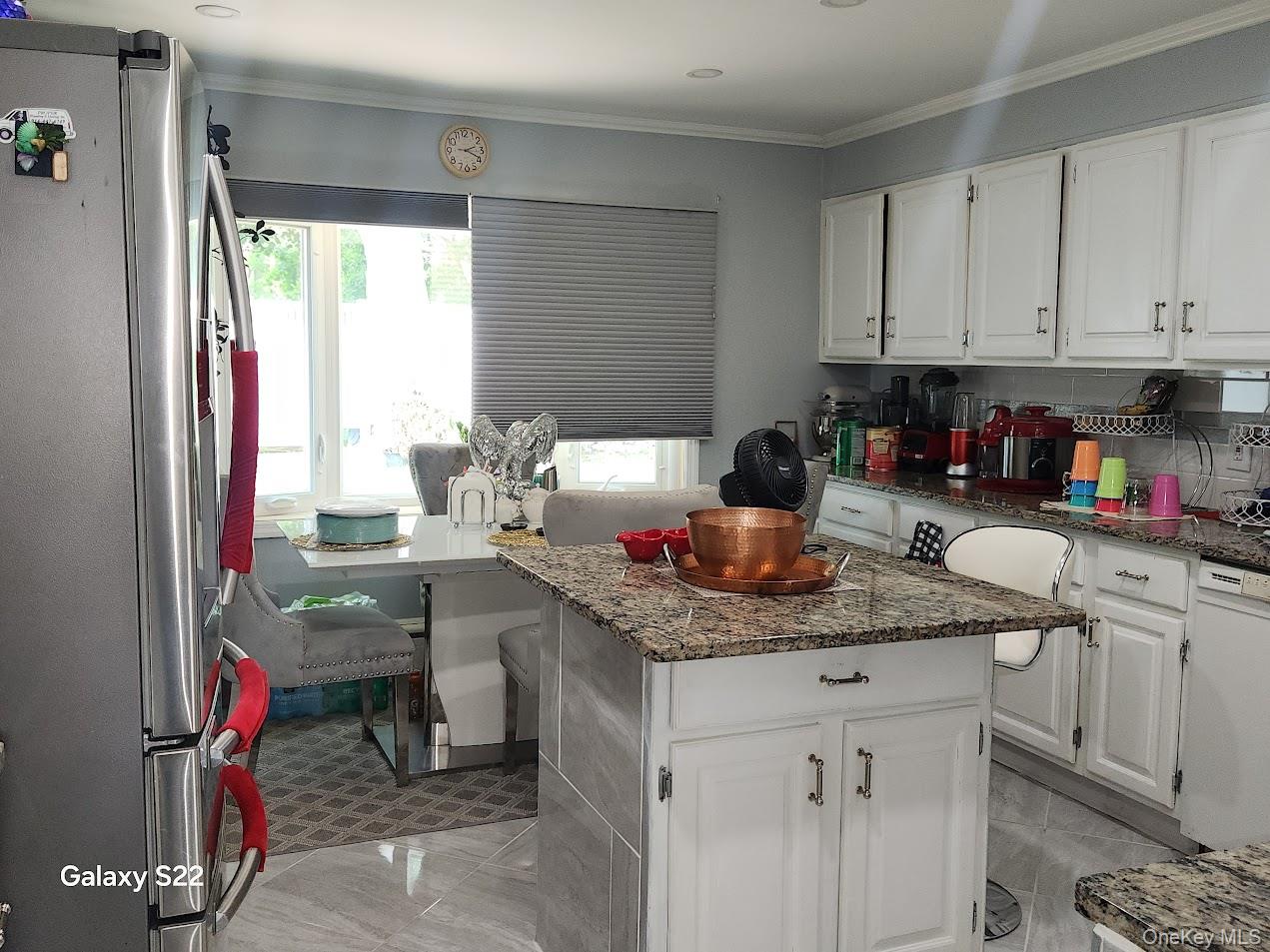 46 Randolph Road White Plains, NY 10607 - Photo 7 of 16 Kitchen featuring freestanding refrigerator, healthy amount of natural light, white cabinets, and ornamental molding