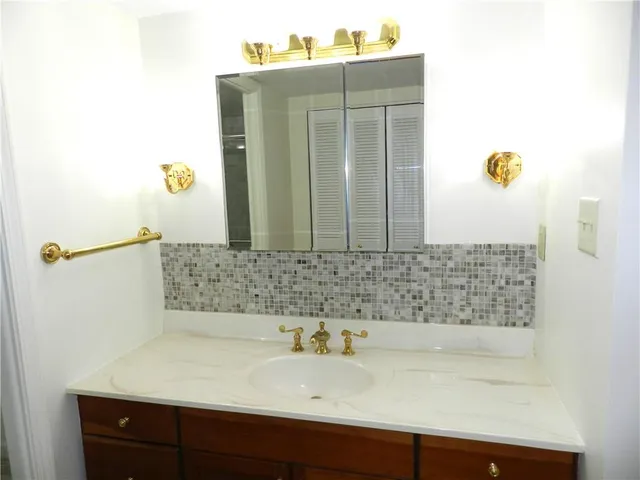 a spacious bathroom with a sink a toilet a large mirror and shower