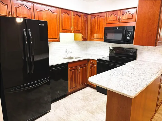 a kitchen with stainless steel appliances a refrigerator a stove a sink and a refrigerator