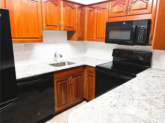 a kitchen with granite countertop stainless steel appliances a stove a sink and a microwave