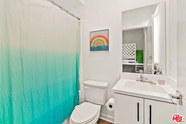 a bathroom with a toilet sink vanity and mirror