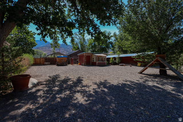 270 East 100 North Monroe, UT 84754 - Photo 49 of 65 Expansive gravel yard featuring mature trees providing ample shade, mountain backdrop, and multiple outbuildings