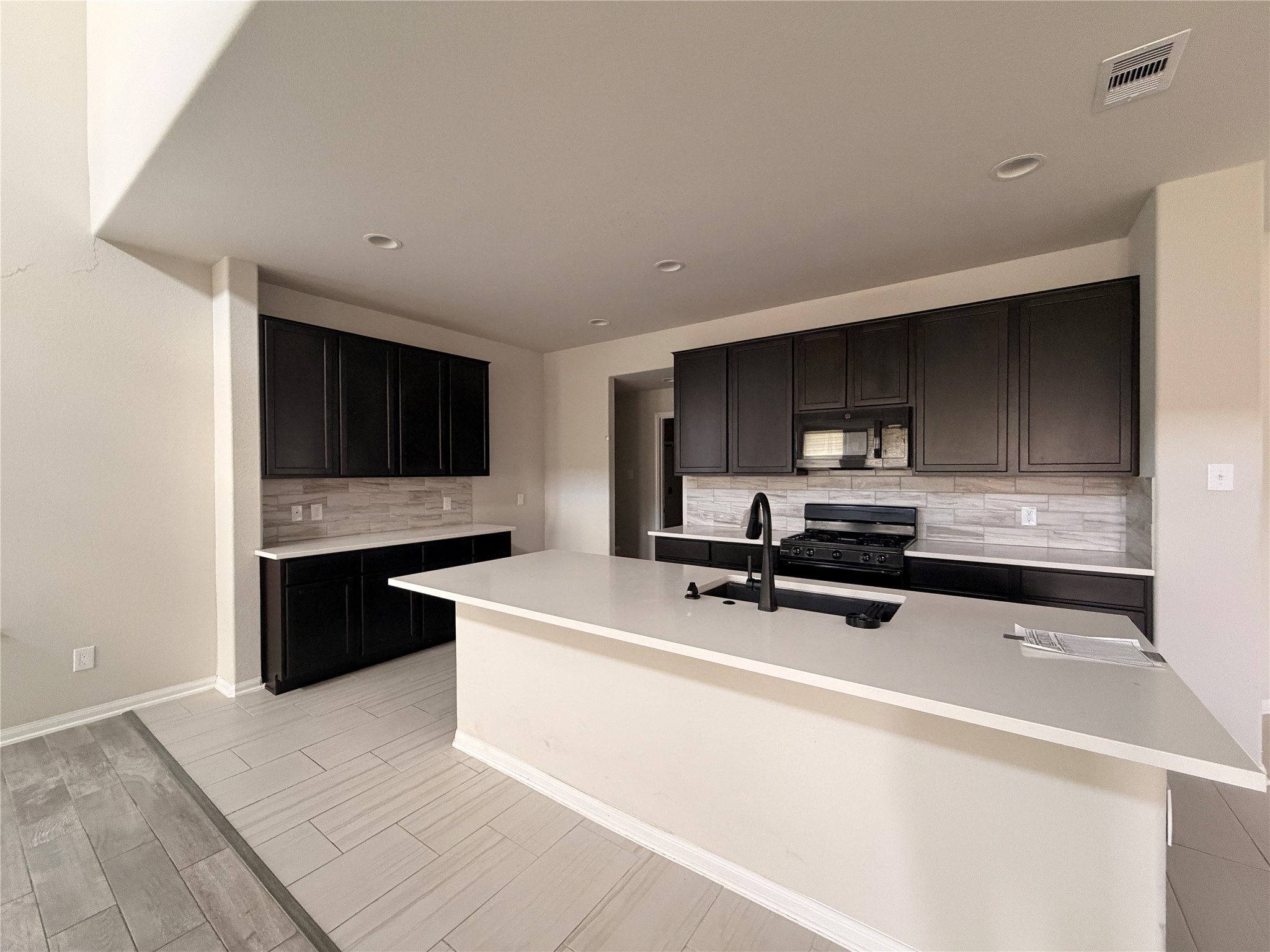 4307 Wyanngate Drive Spring, TX 77373 - Photo 11 of 21 a kitchen with stainless steel appliances a sink a stove a microwave a sink and cabinets